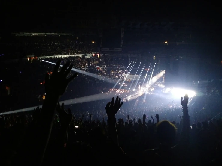 many people waving their hands in front of the crowd