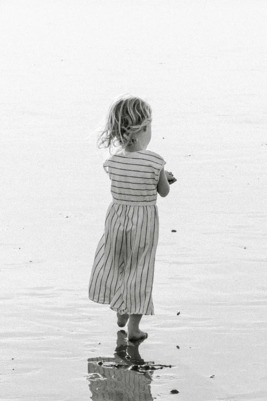 black and white pograph of little girl looking at ocean water