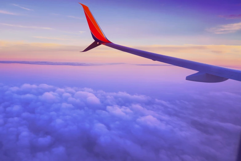 a large commercial jetliner flying over a colorful sky