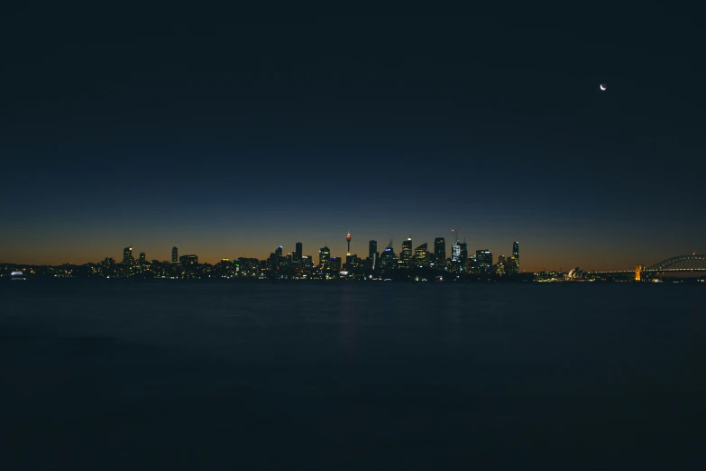 view from water at night with the city and clouds glowing