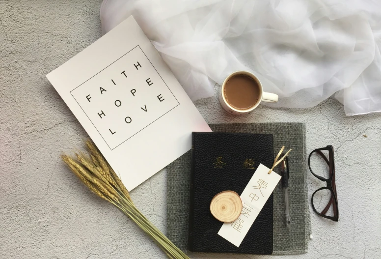 the table is covered in items such as a notebook, sunglasses, and card