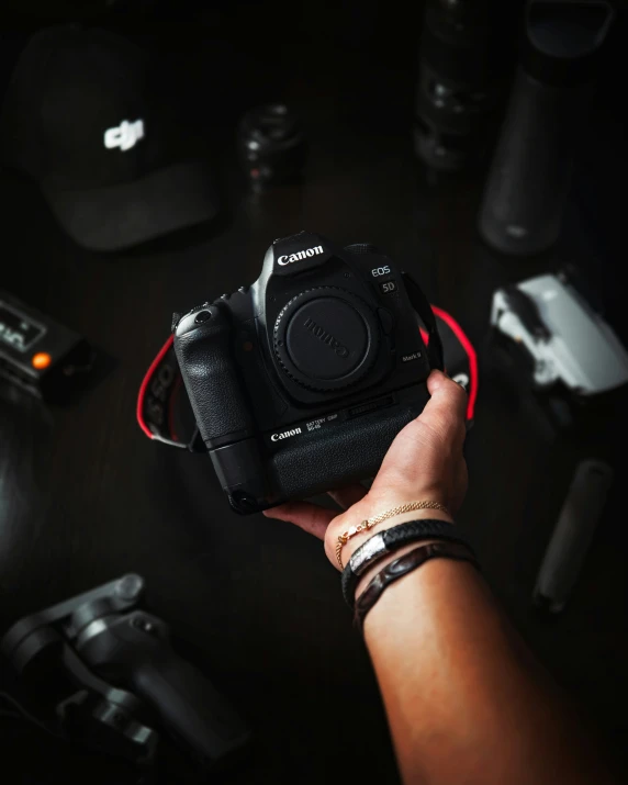 hand holding a camera over a black table