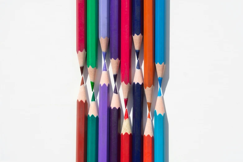 several colored pencils in a row lined up