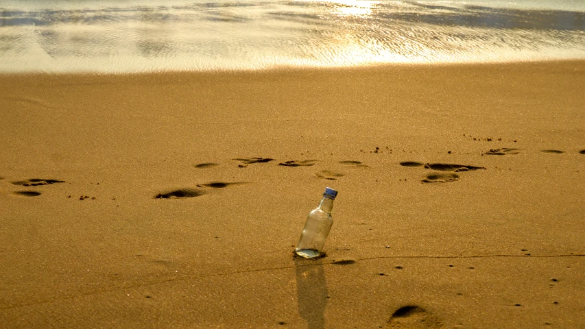 a bottle with a note inside sitting in the sand