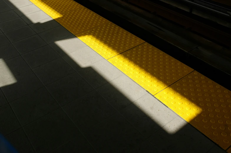 a shadow of a train on the platform