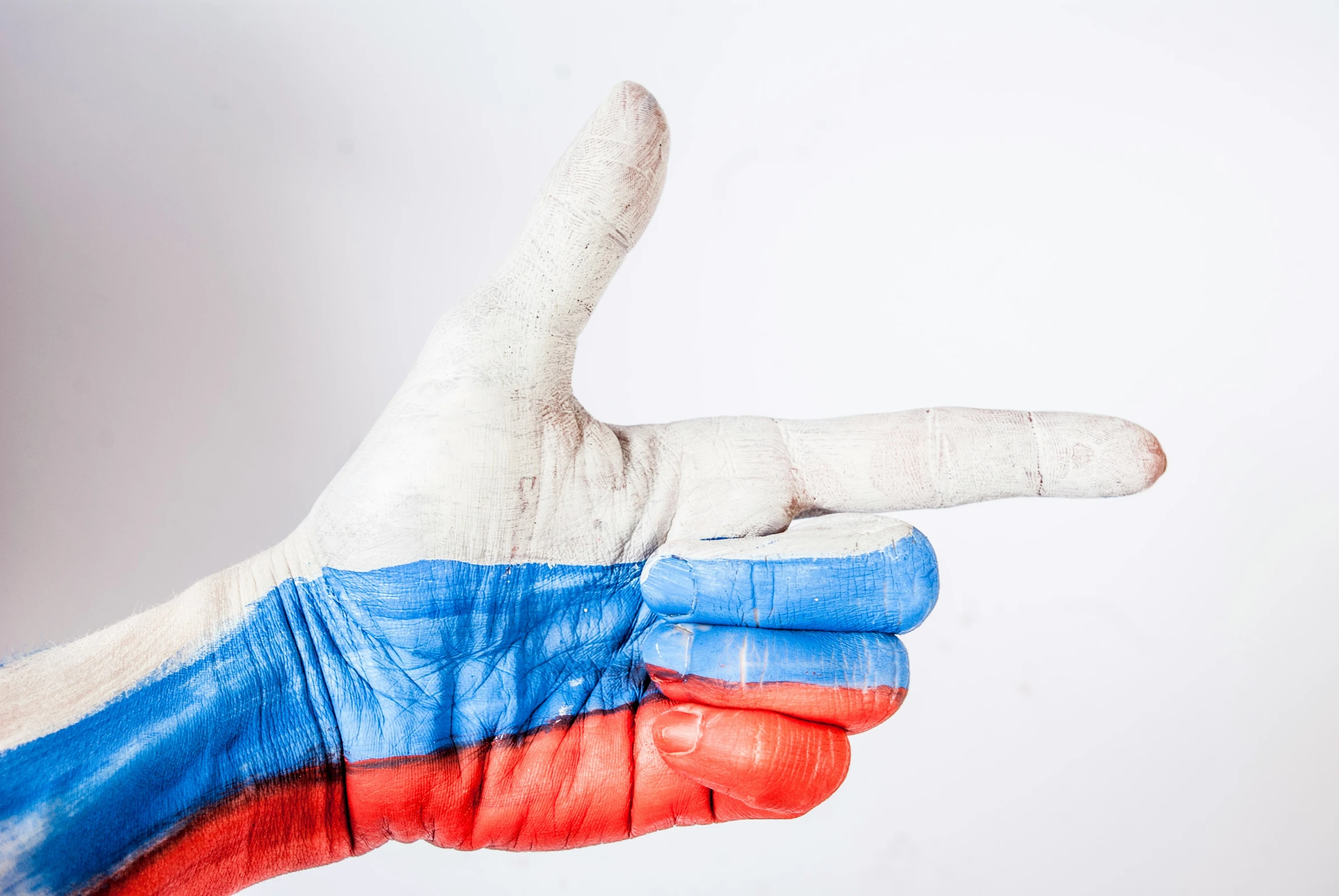 a close up of a person's hand with a painted russian flag thumb pointing down