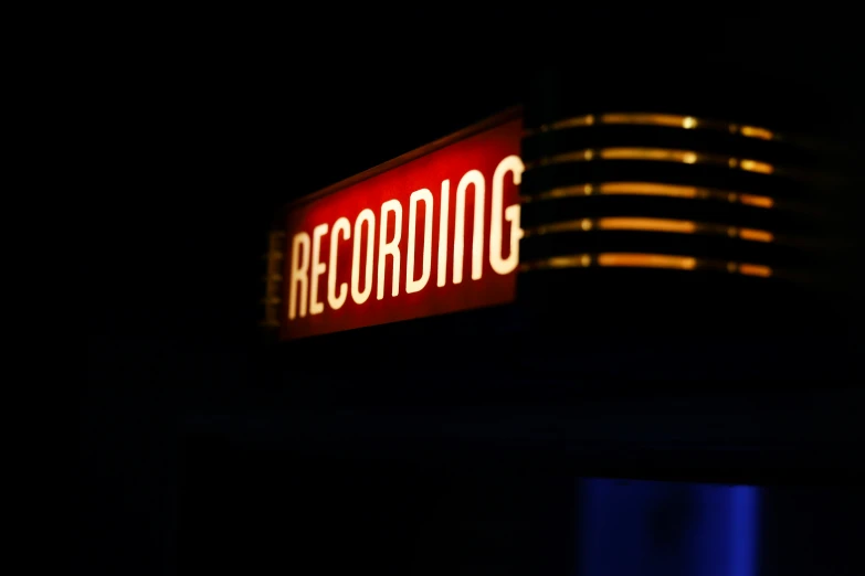 an illuminated sign sits on the side of a building