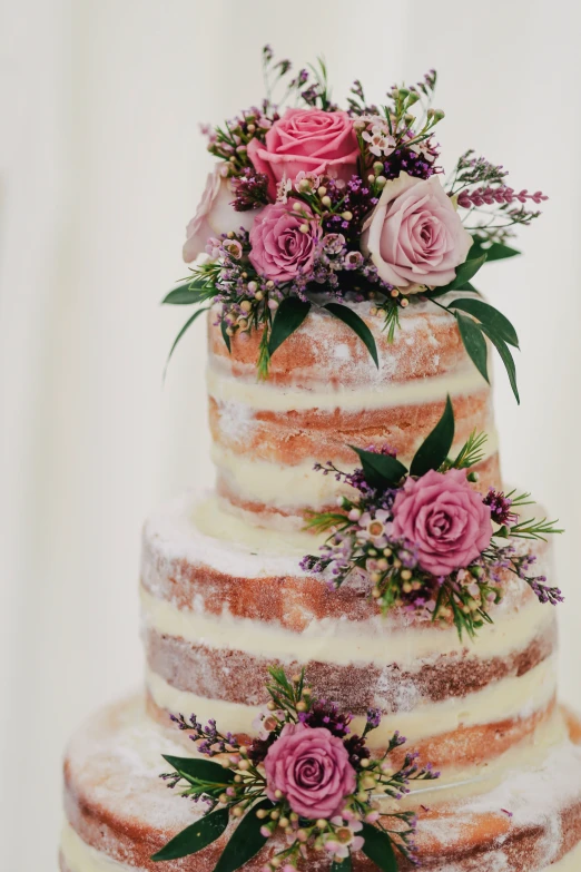 a tiered wedding cake decorated with pink flowers