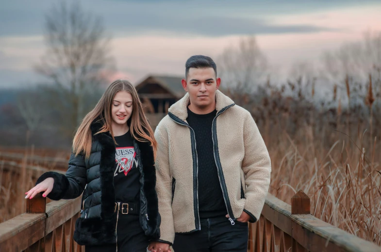 a couple walking on a boardwalk holding hands