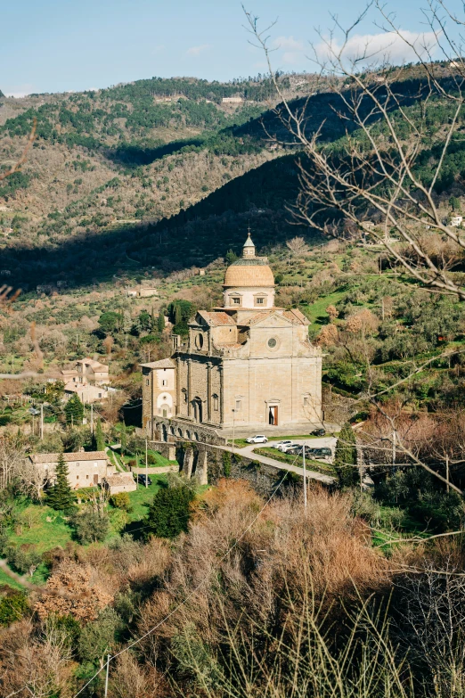 a old house in a hill side with trees and bushes