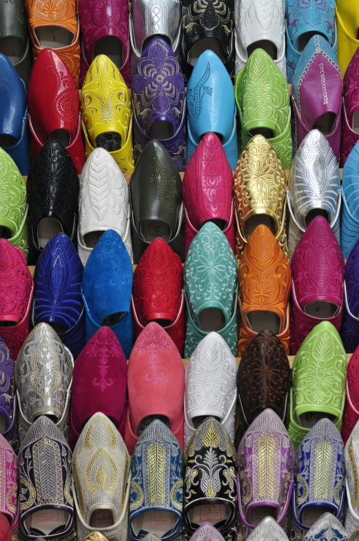 a pile of different colored shoes sitting next to each other