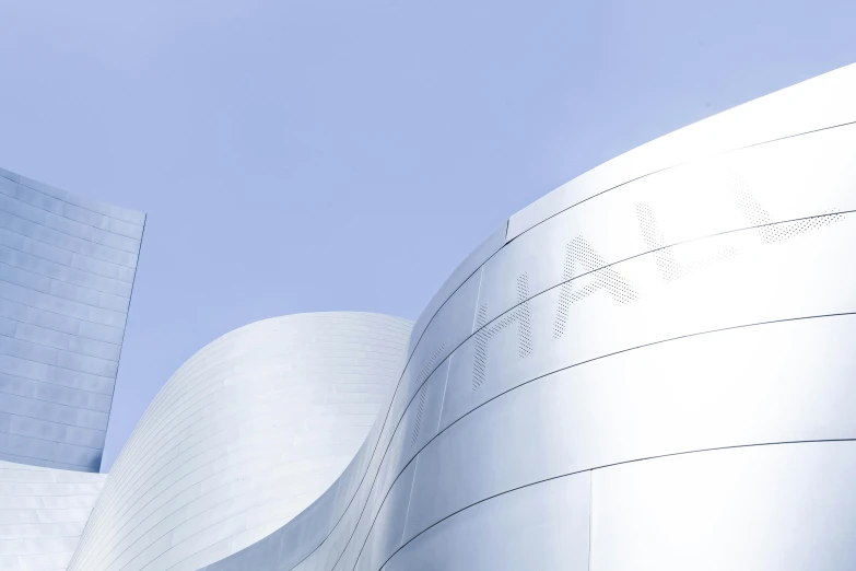 two large curved buildings are against the sky