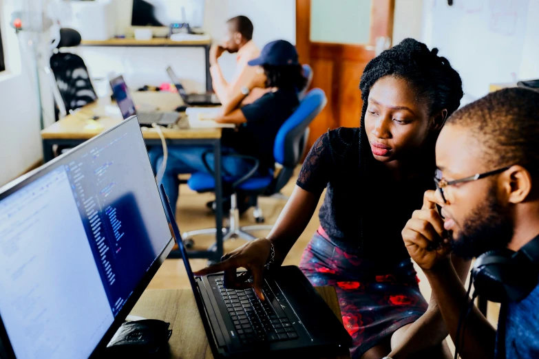 two men and a woman siting at their computers