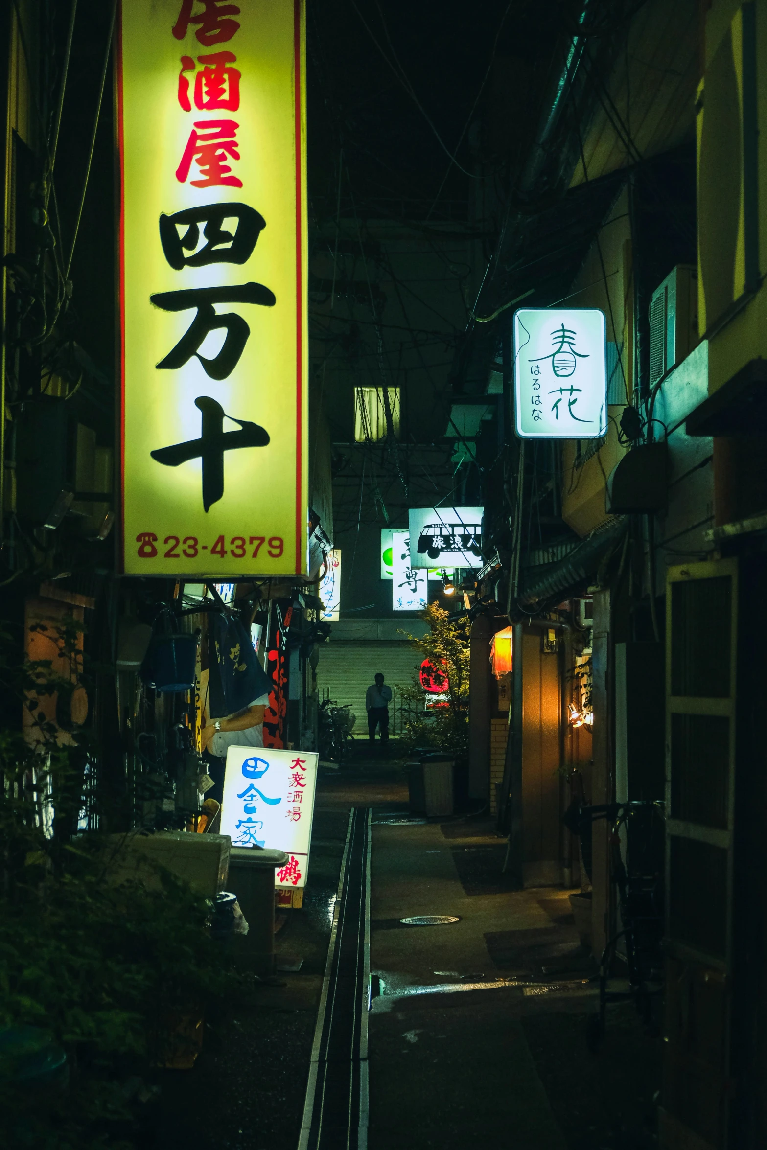 a narrow alley way in a city during the night