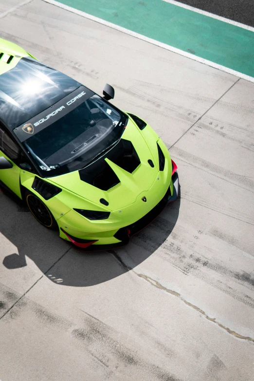 a close up of a green sports car on a racetrack