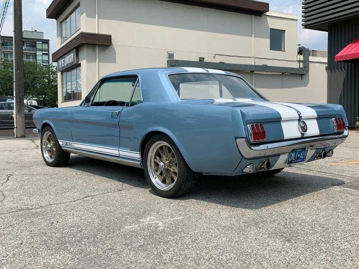 the blue mustang parked outside the building is very clean