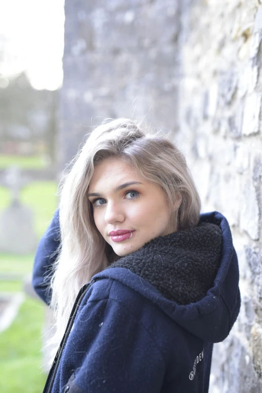 a young blonde woman with a black sweater on