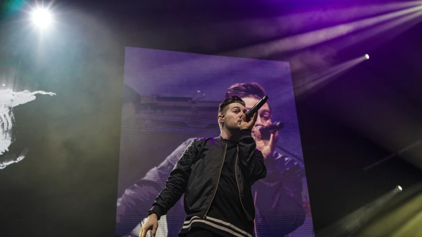 a person standing under bright lights with his hand on his face