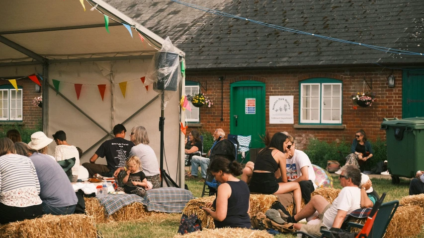 several people are having a picnic party in a straw field