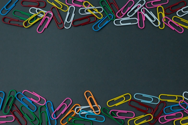 a pile of paper clip with colored text on a black background