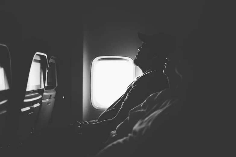 a man sitting in an airplane with two windows