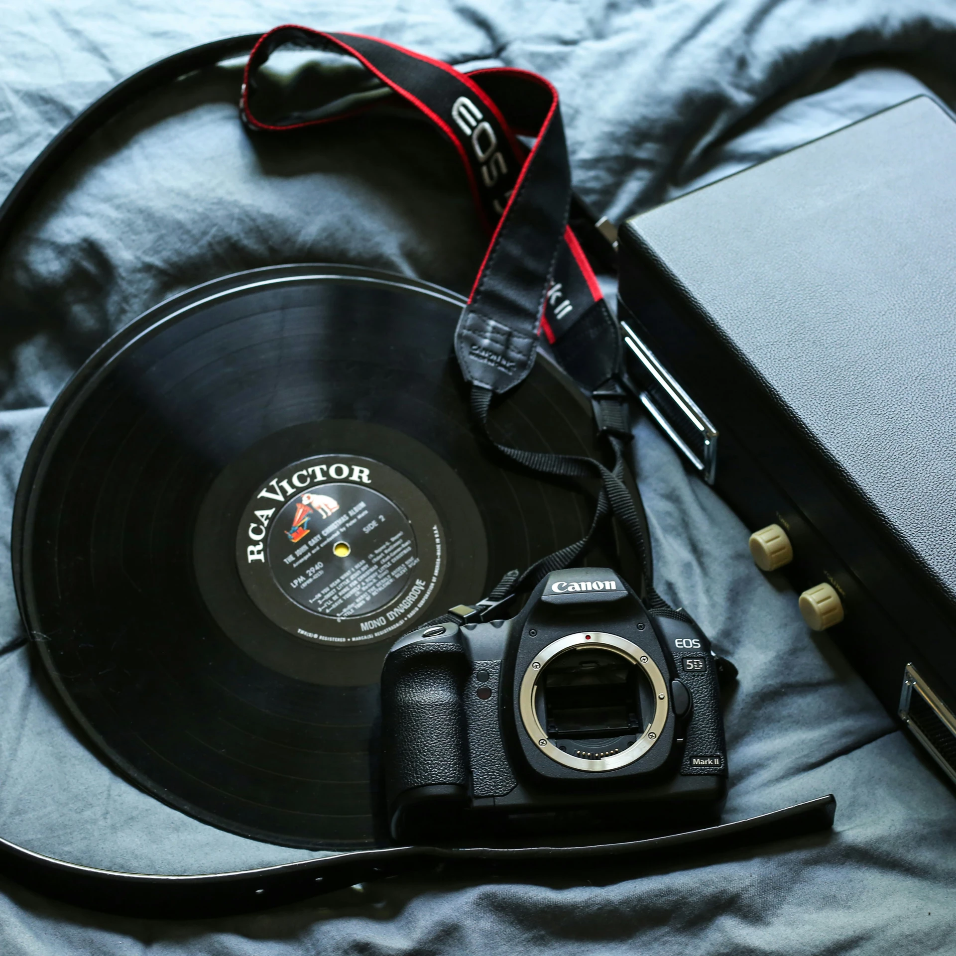 a digital camera and a record player on the bed