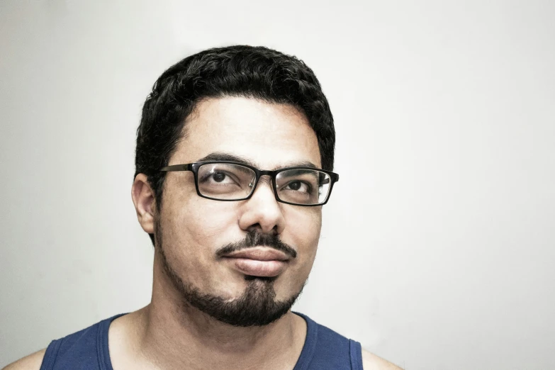 a man in glasses is looking directly into the camera