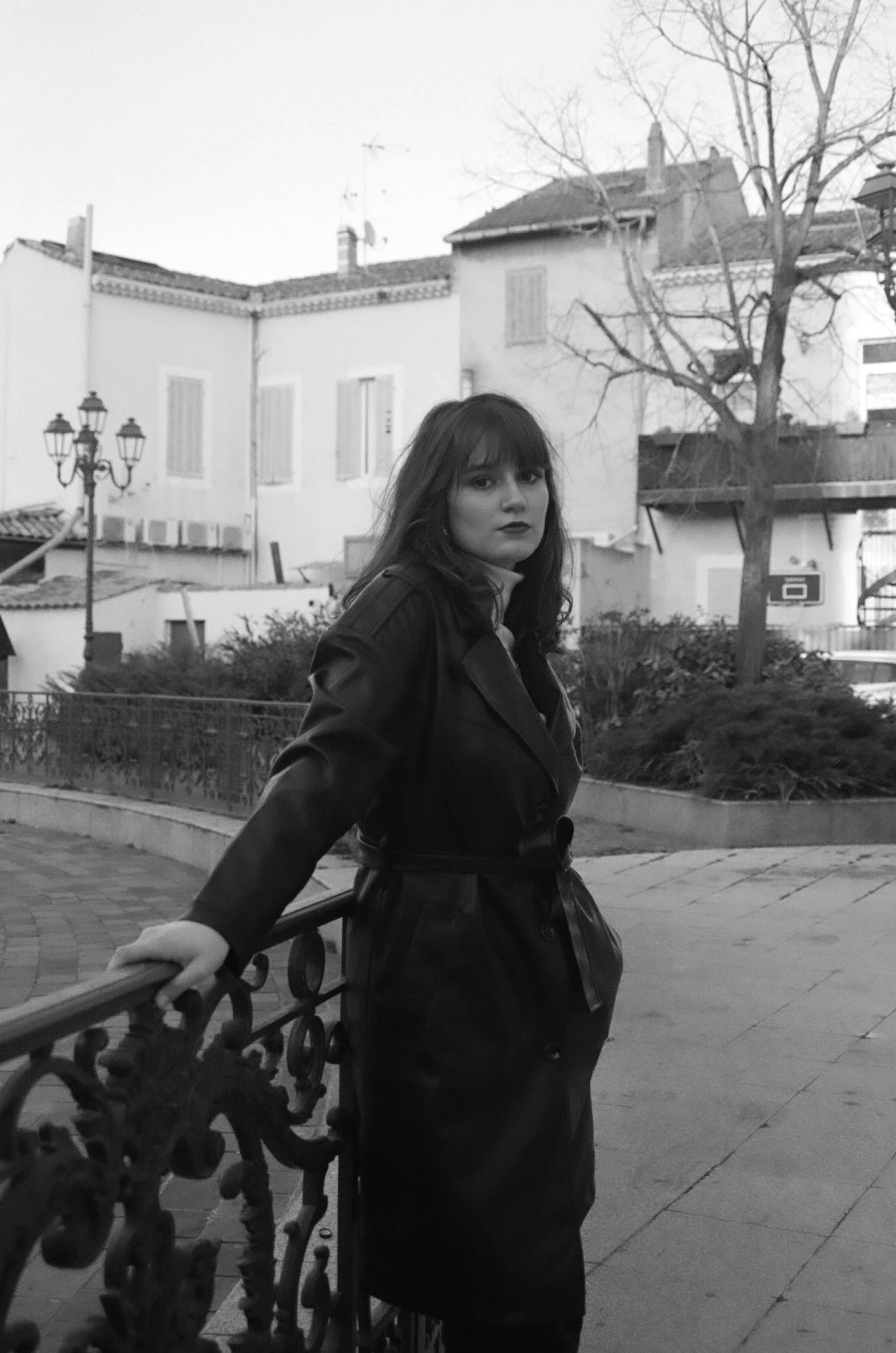 a black and white po of a woman leaning on a railing