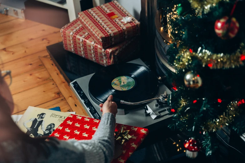 a hand reaching for a record player that is on top of a table