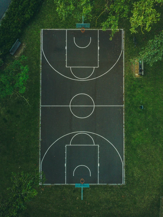 an overhead view of a basketball court with green trees