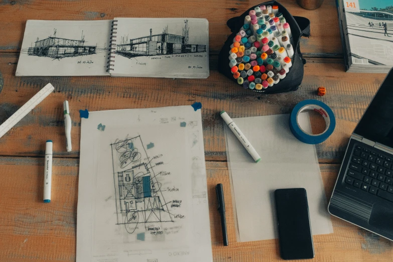 an arrangement of pencils, marker pens and papers on a table