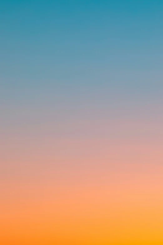 an orange and blue sky with a airplane flying