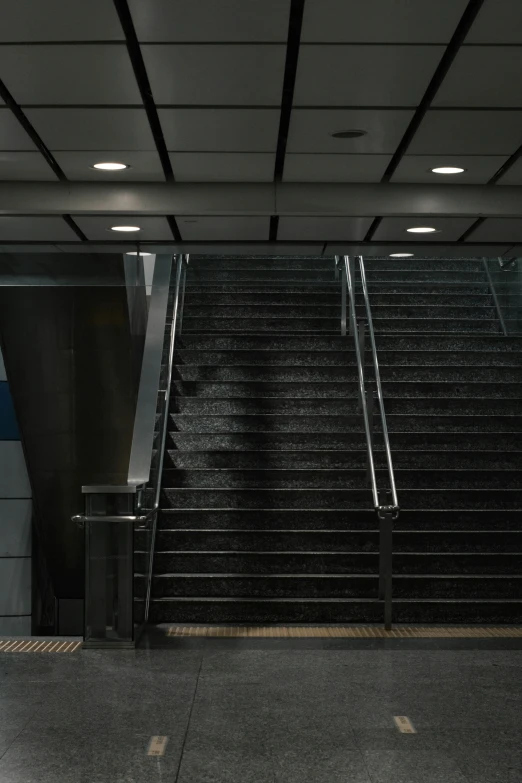 a long staircase in an airport has railings on each side