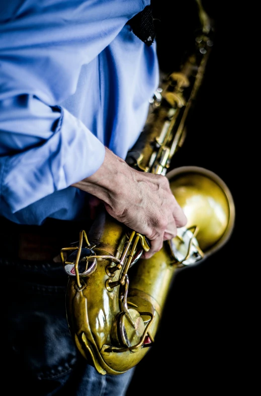 a man playing the saxophone against a black background