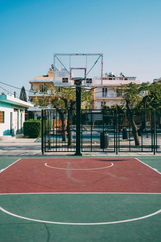 a basketball court and an apartment building behind it