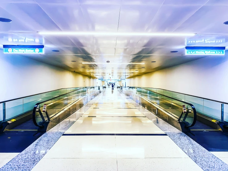 empty escalators at an airport with signs above them