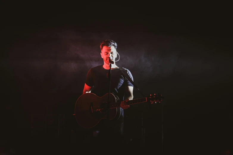 a person playing guitar while standing on stage