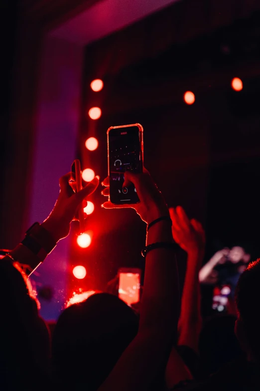 a woman taking pictures with her phone in the dark