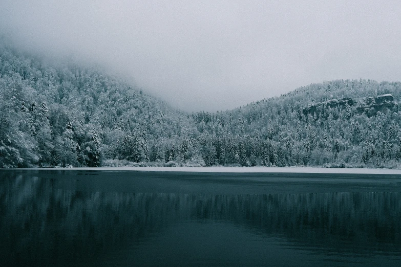 there is snow on a snowy mountain and a body of water