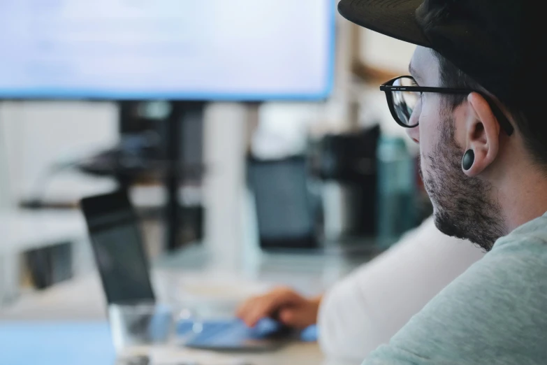 a man sitting at a table with a laptop computer