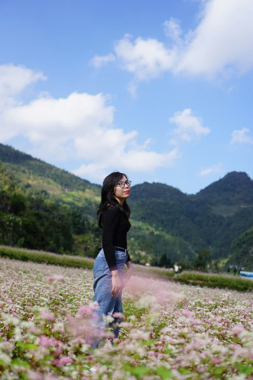 a girl stands in the middle of a field