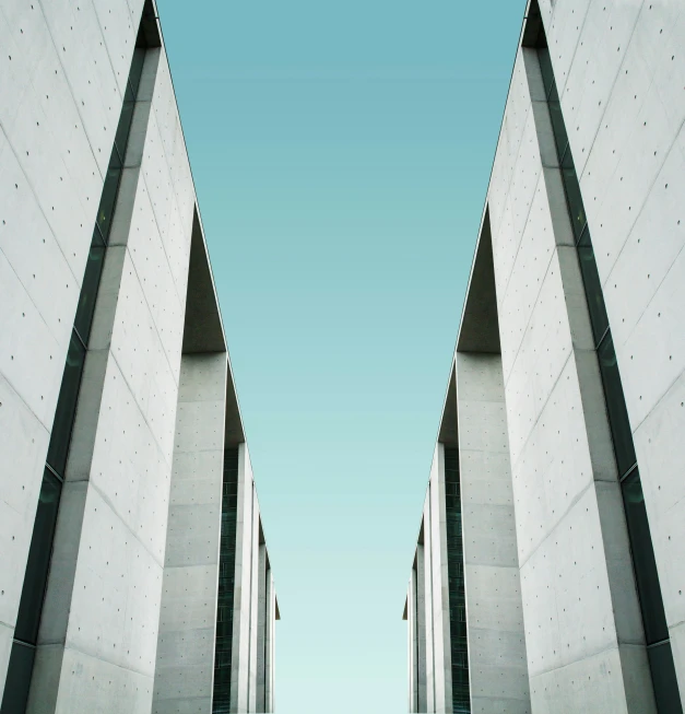 an empty walkway lined with tall white concrete walls