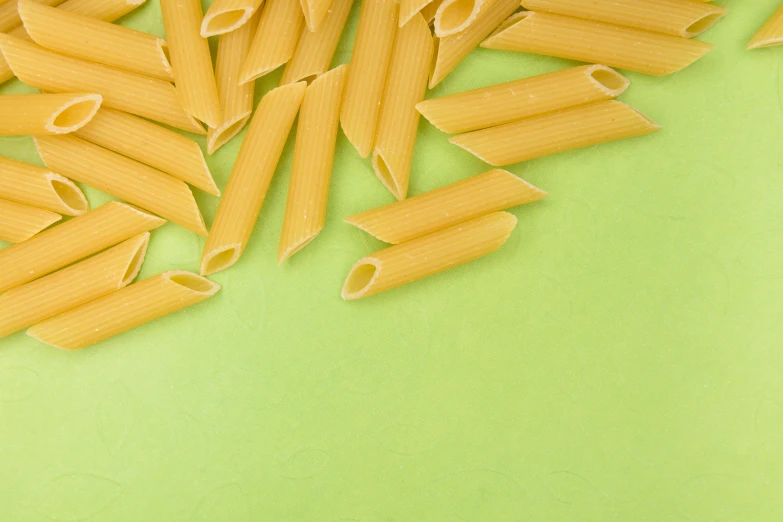 several small piles of italian pasta sit atop a green surface