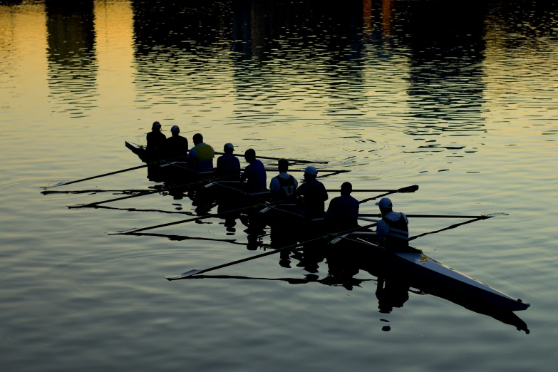 a long rowing boat with eight rowers are in the water