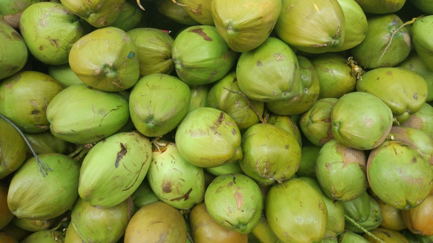 a bunch of raw green apples sitting on the ground