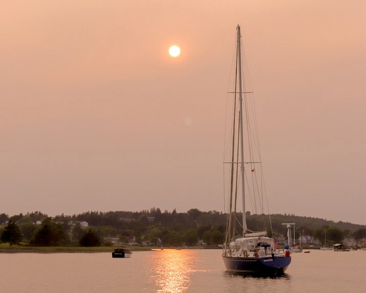 there is a boat that is on the lake at sunset