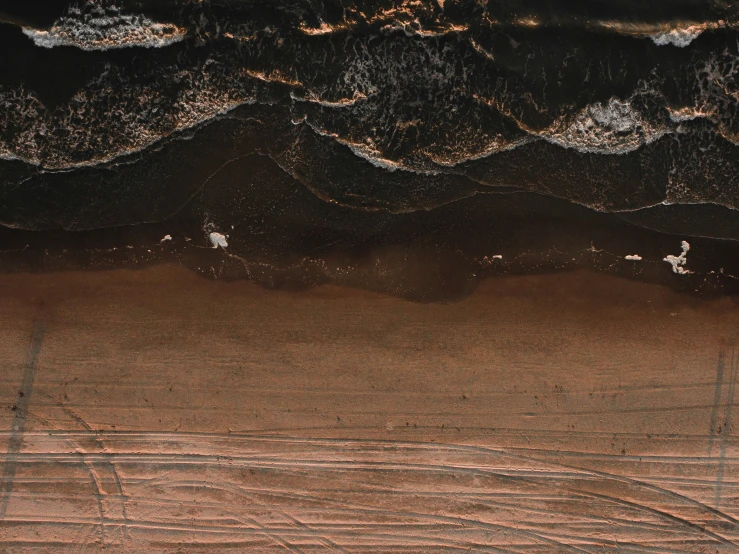 people are walking on the sand and waves crashing over