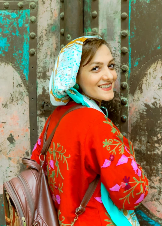 a woman in red shirt carrying a bag and a handbag