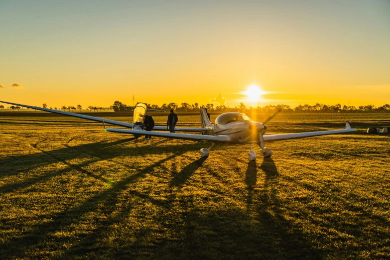 two men sit in a plane on the grass