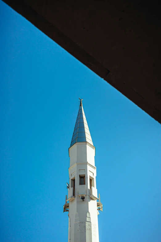 a white building has a blue roof and a clock on the side